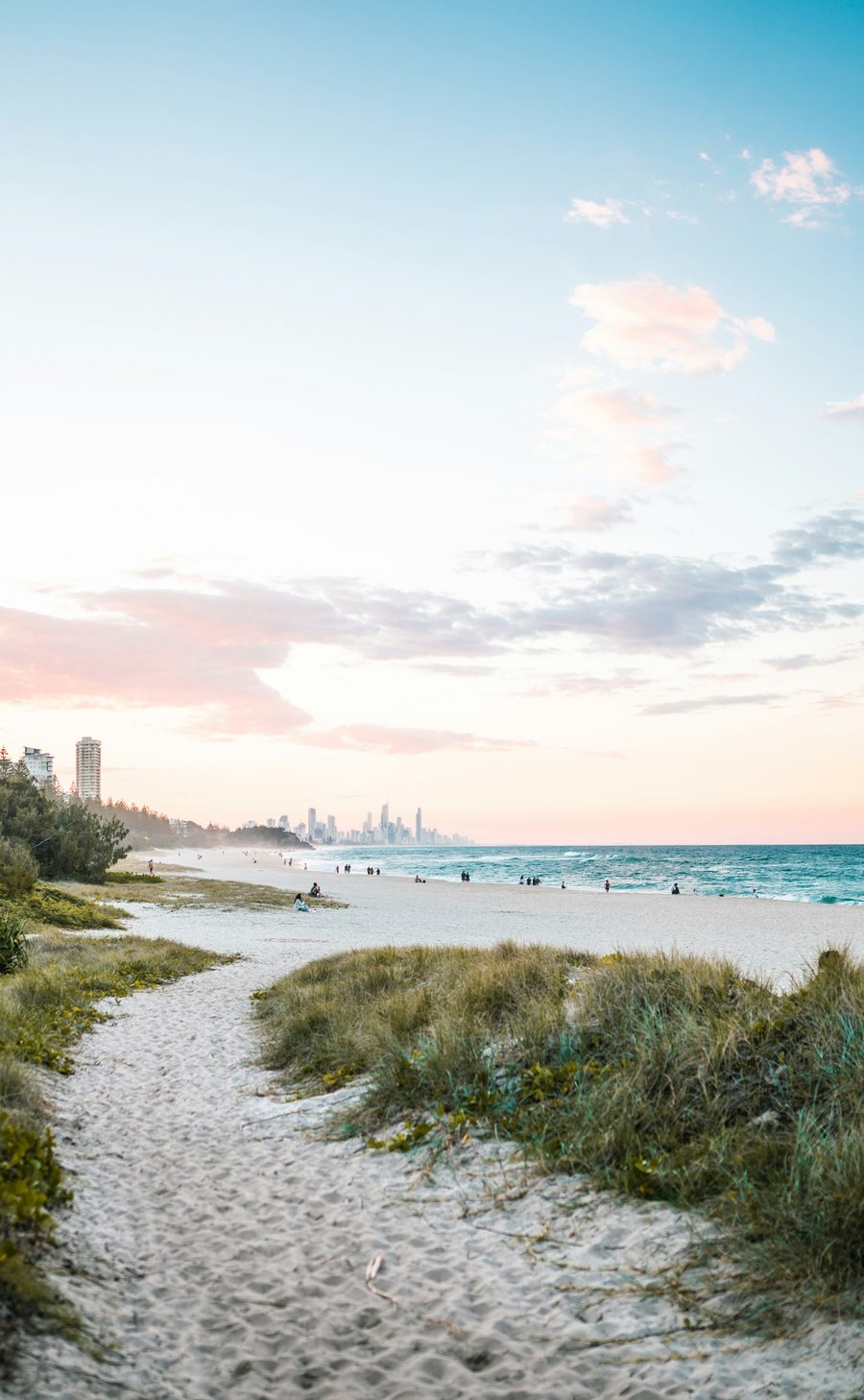 Path through the dunes onto the beach at Burleigh Heads, Surfers Paradise in the distance